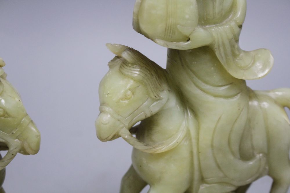 A pair of Chinese bowenite jade groups of a lady riding a horse, wood stands total height 26.5 and 27cm